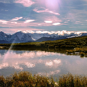 Paesaggio alpino con laghetto, cielo e montagne